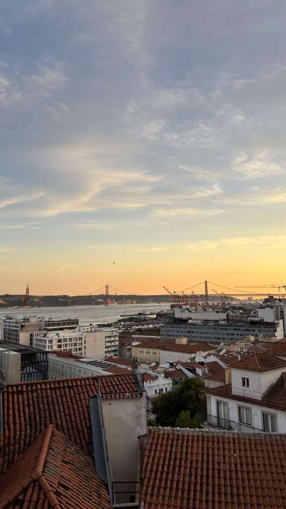 view of sunset in lisbon over the bridge and river