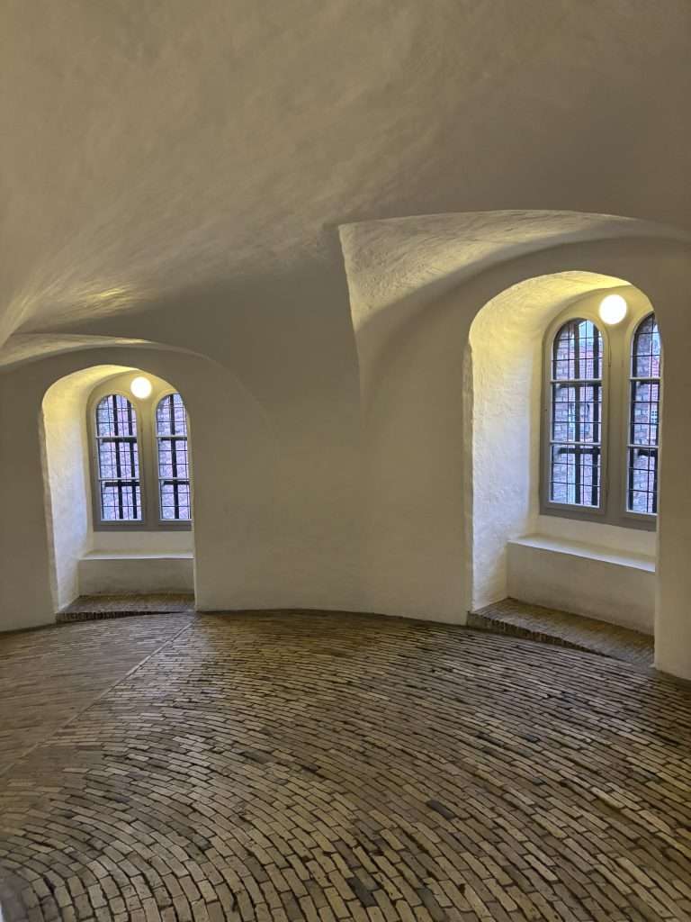 The bright interior corridor of the Round Tower featuring tall windows and the famous spiral path without stairs.