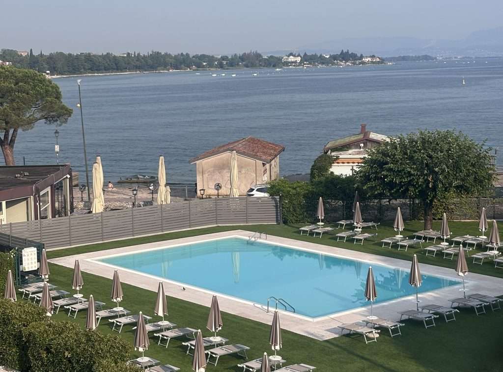 a view of the pool and lake of hotel ristorante al fiore in lake garda