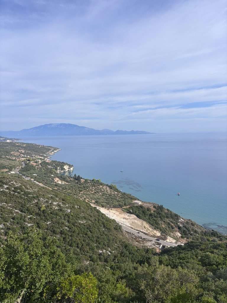 Panoramic view of Zante’s coastline from Navagio viewpoint, overlooking the sea, green hills and distant islands.